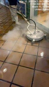steaming the tile by a floor cleaning company in North Miami