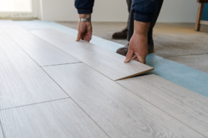 Man laying down Vinyl Plank Flooring in North Miami 