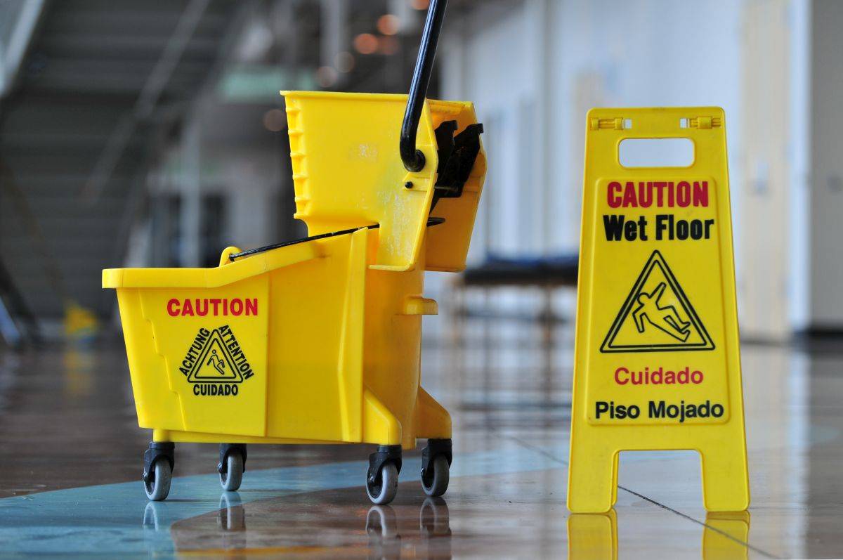 Mop bucket and caution sign being used by Office Cleaning Companies in Fort Lauderdale, Aventura, Doral, Coral Gables, Kendall, Miami